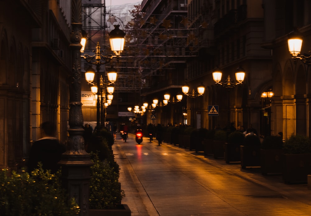 a city street at night with street lamps and scaffolding
