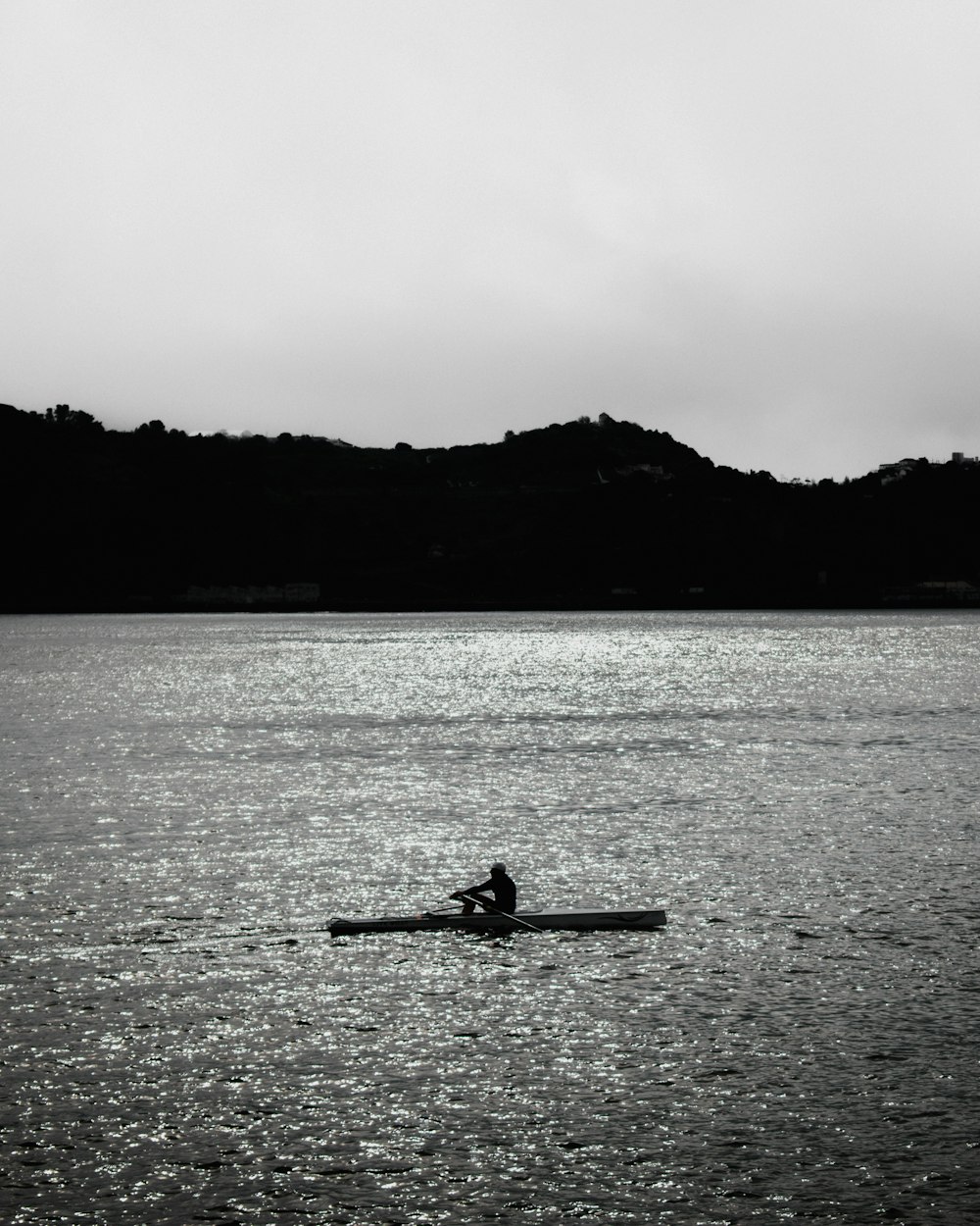 a person rowing a boat on a large body of water