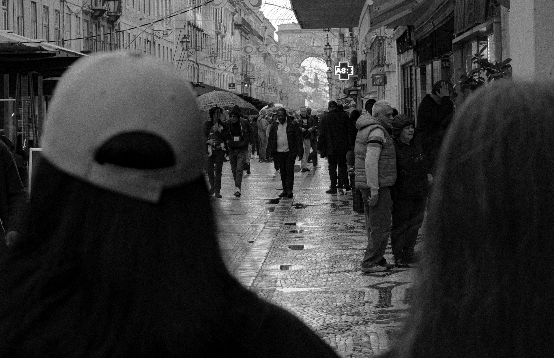 a black and white photo of people walking down a street