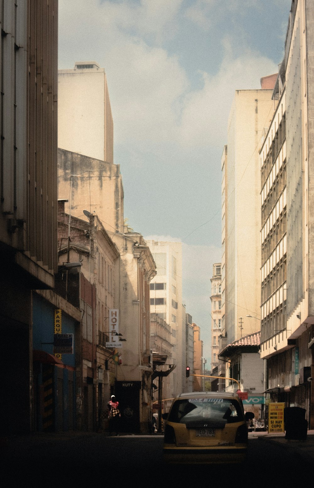 a car driving down a street next to tall buildings