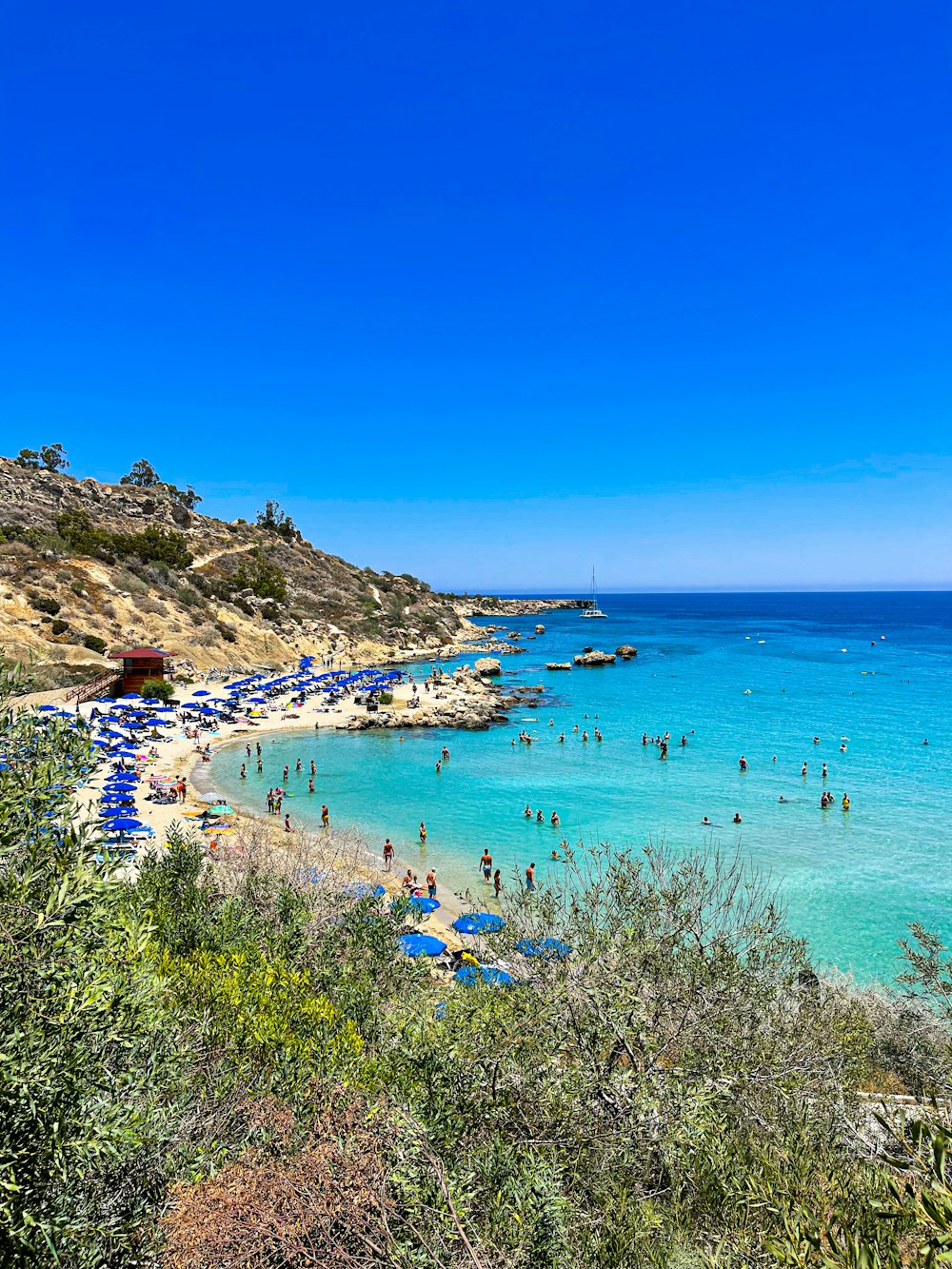 una playa llena de mucha gente bajo un cielo azul