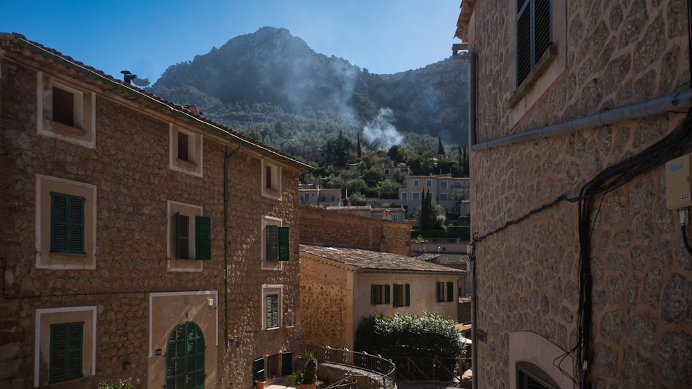 a narrow street with a mountain in the background