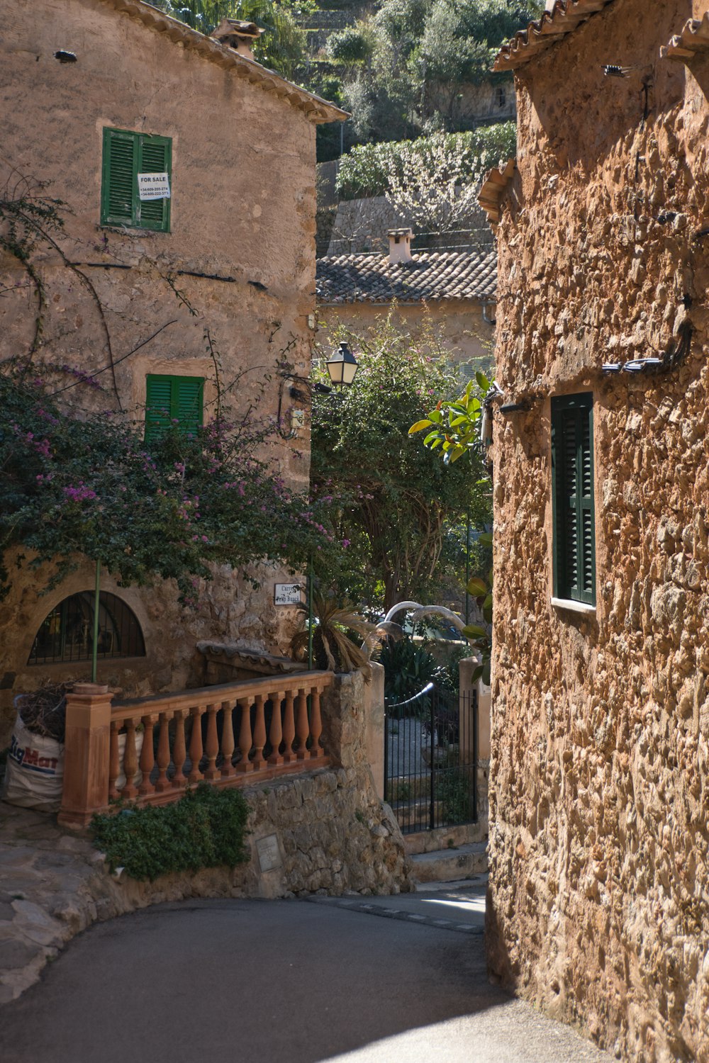 a stone building with green shutters and a balcony