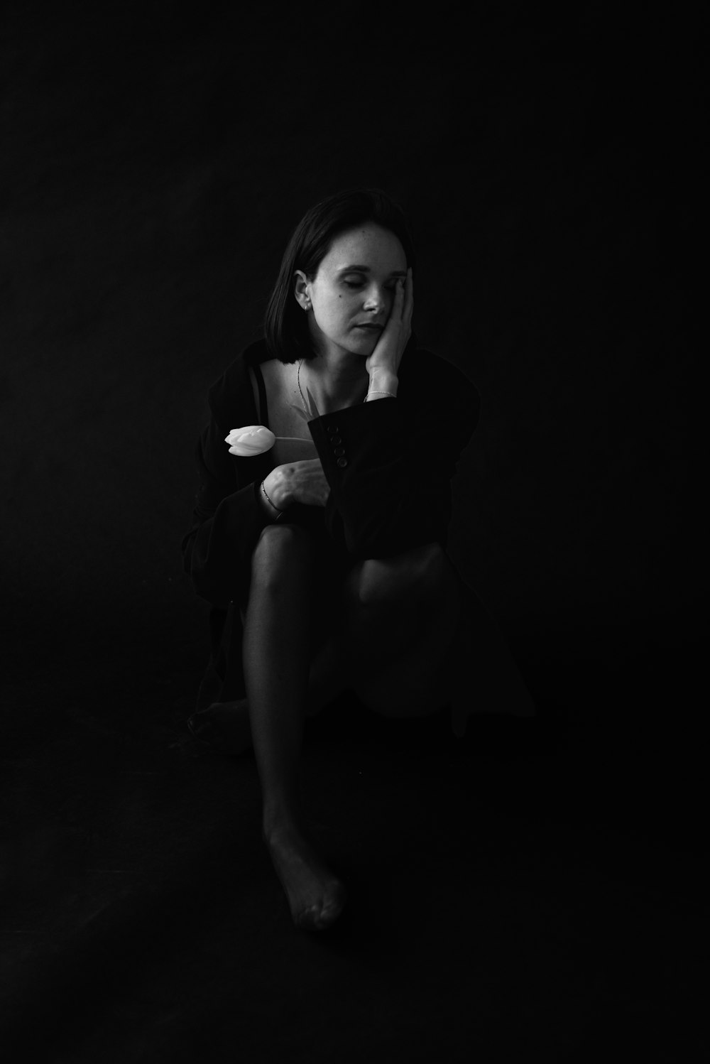 a black and white photo of a woman holding a cat