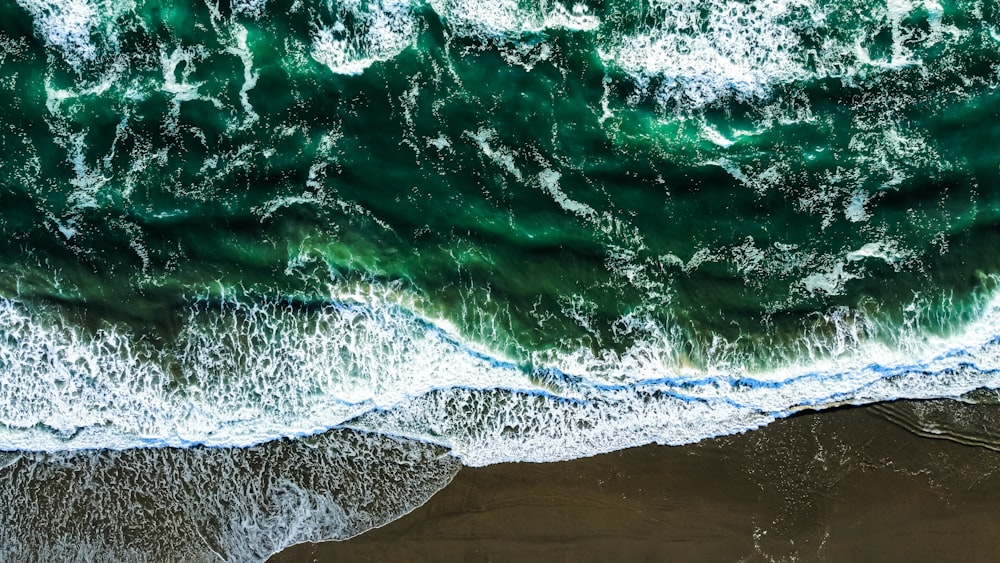 an aerial view of a beach with waves crashing on it