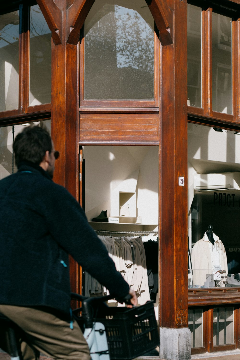 a man riding a bike past a store window