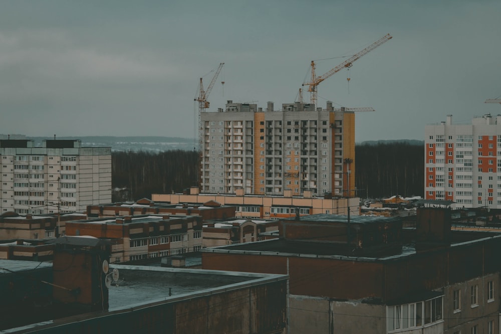 a view of a city with cranes in the background