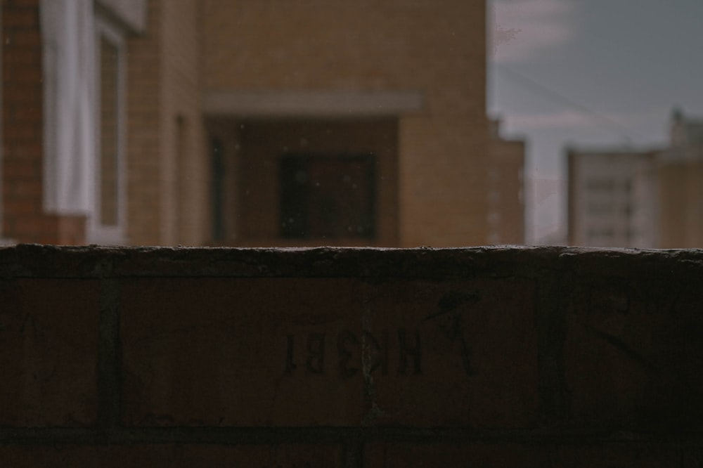 a brick wall with writing on it in front of a building