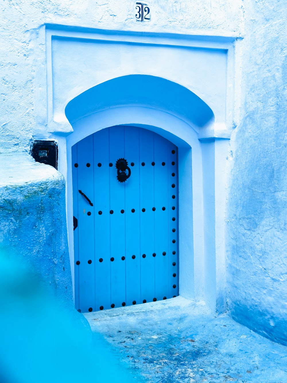 a blue door with a hole in the middle of it