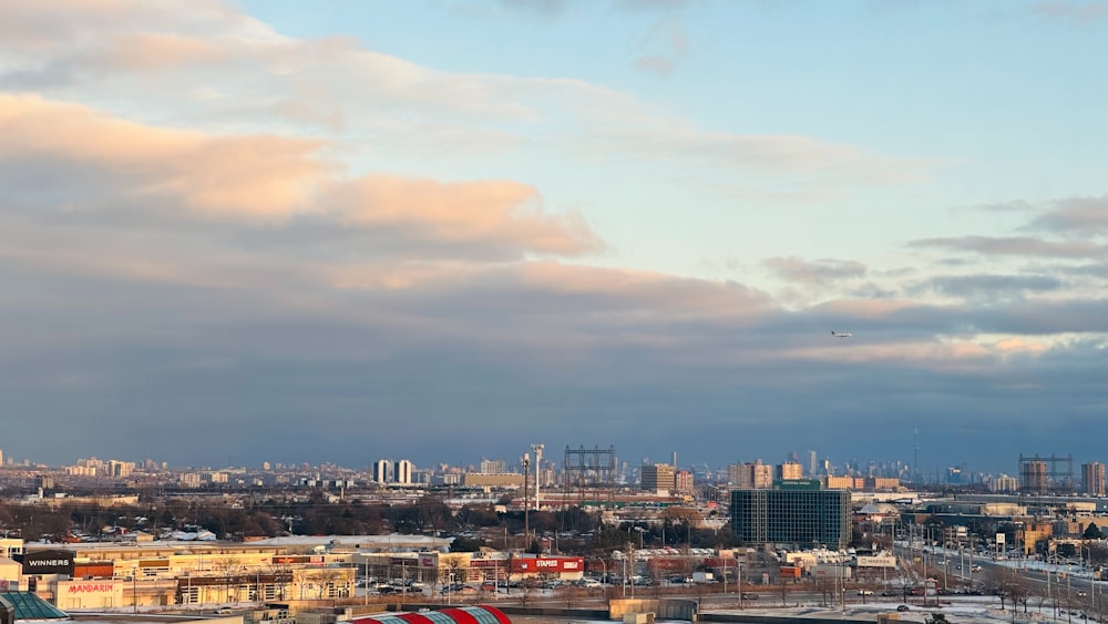 a view of a city with a plane flying in the sky