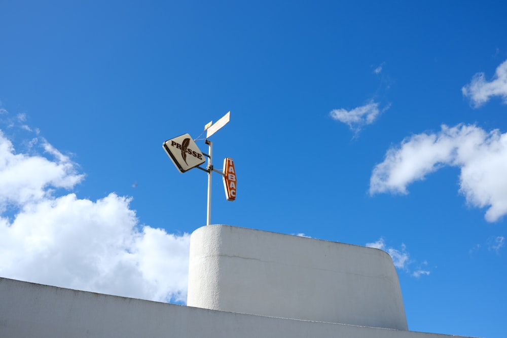 a street sign on top of a white building