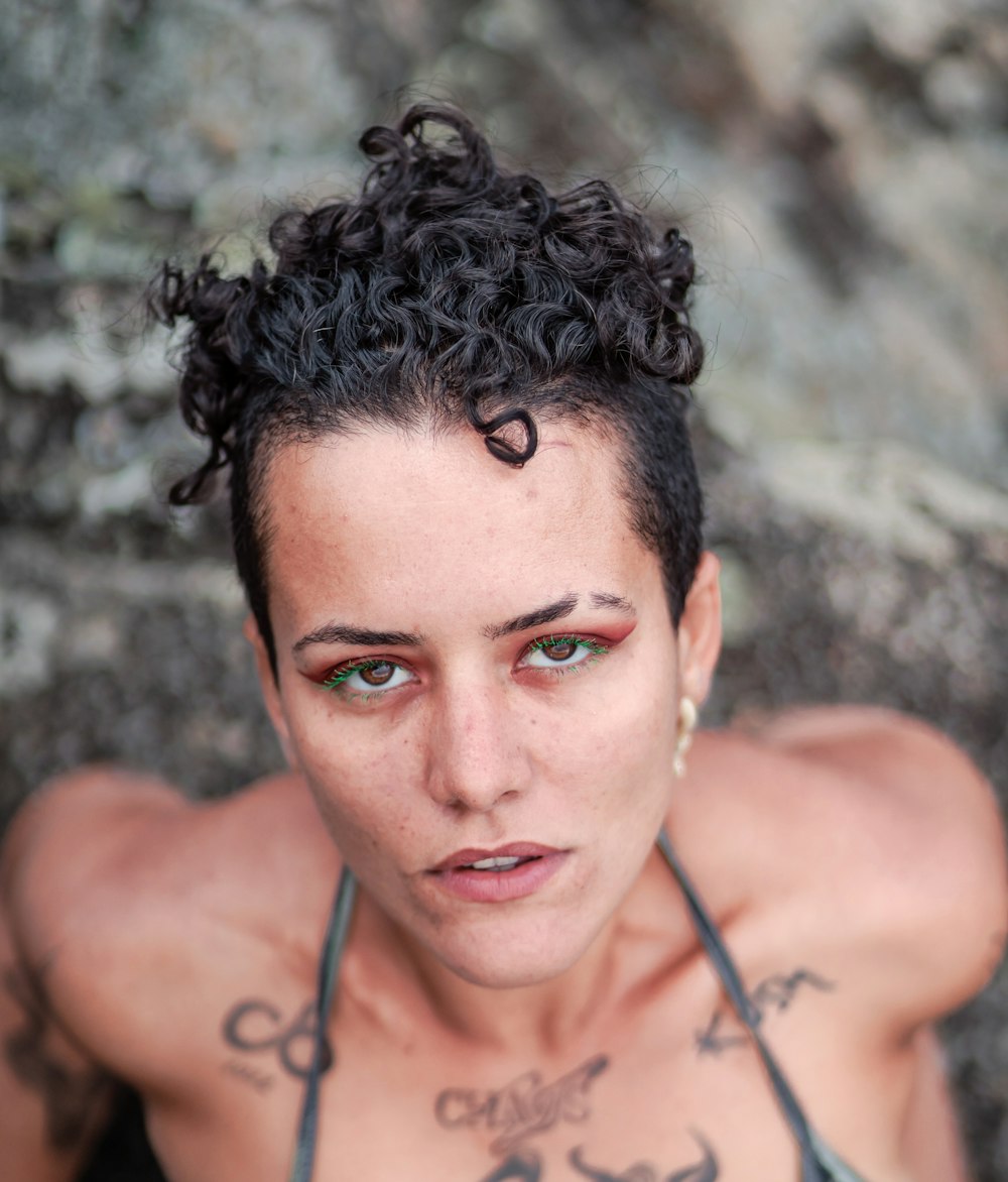 a woman with tattoos on her chest posing for a picture