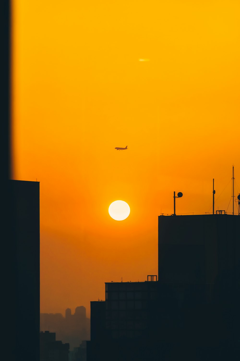 a plane is flying in the sky at sunset