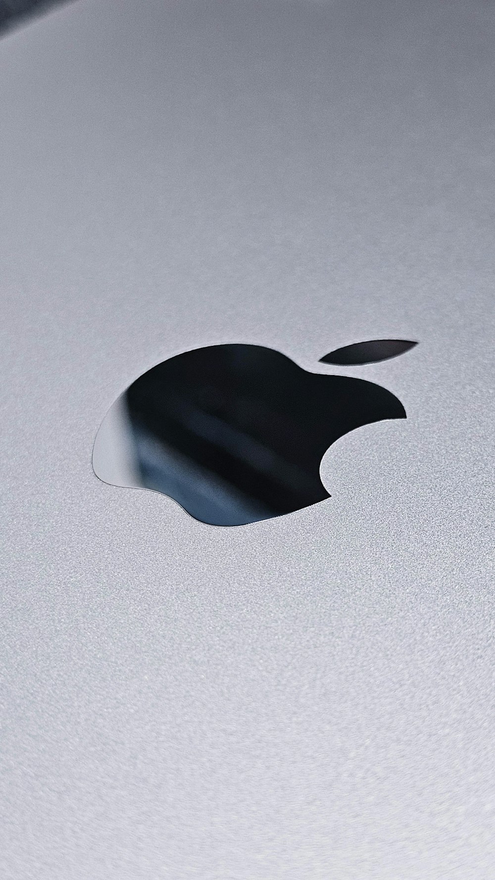 a close up of an apple logo on a silver surface