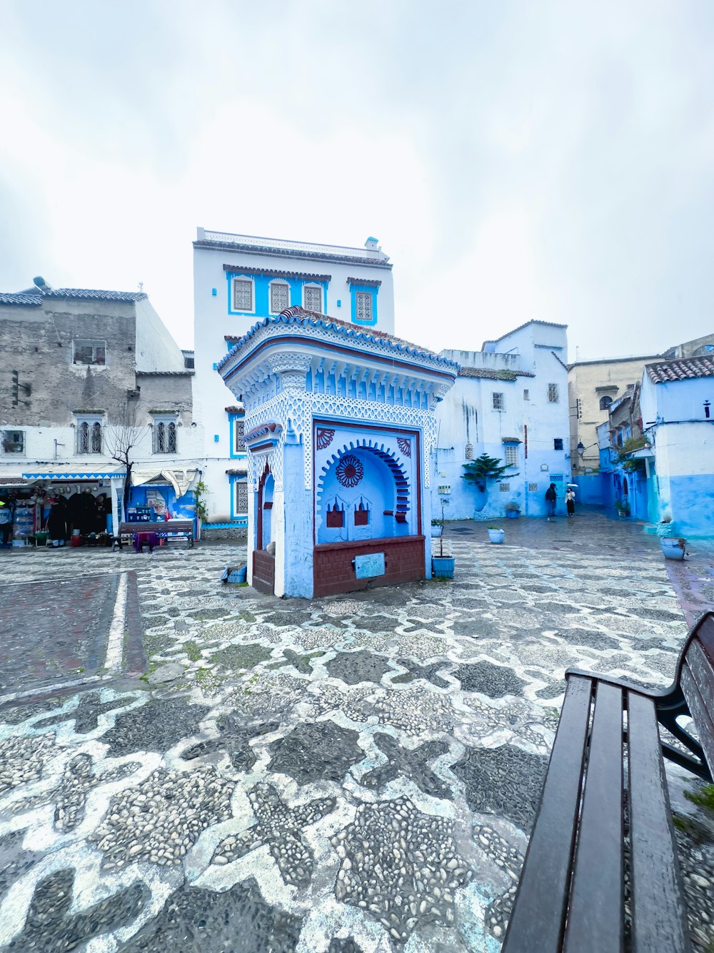 a bench sitting in front of a blue building