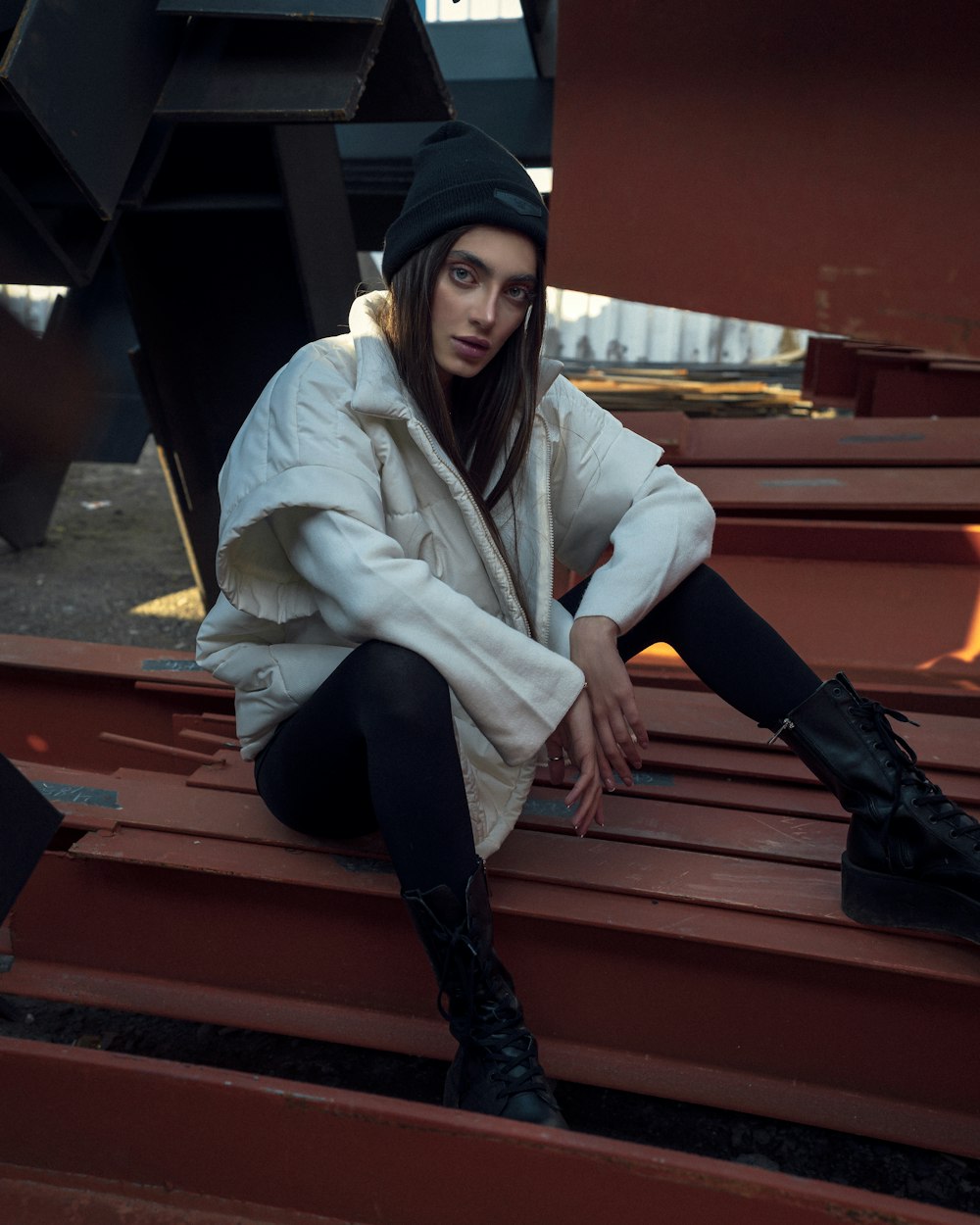 a woman sitting on top of a wooden bench