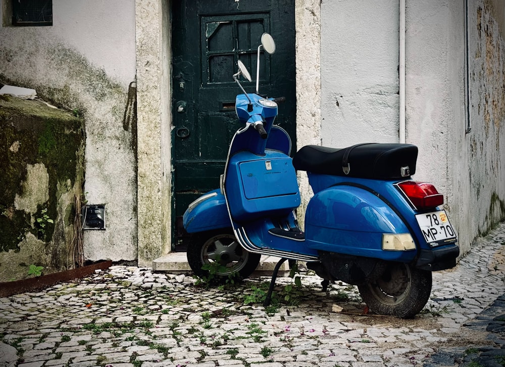 a blue scooter parked in front of a door