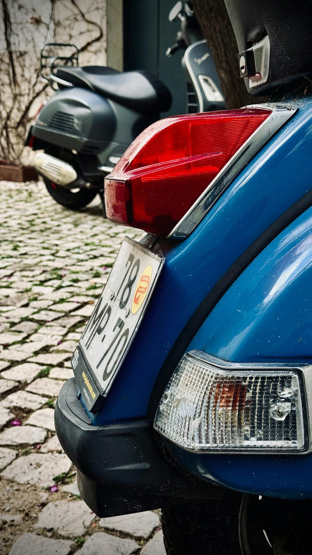 a blue motorcycle parked on a cobblestone street