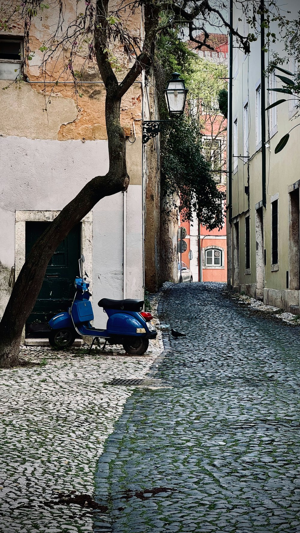 a motor scooter parked on a cobblestone street