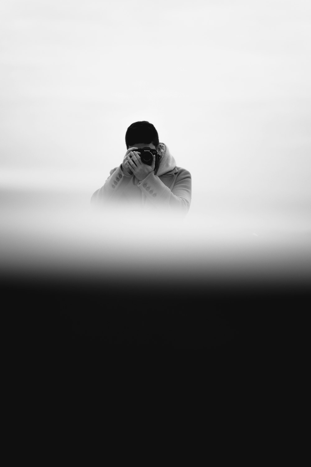 a black and white photo of a person covering their face
