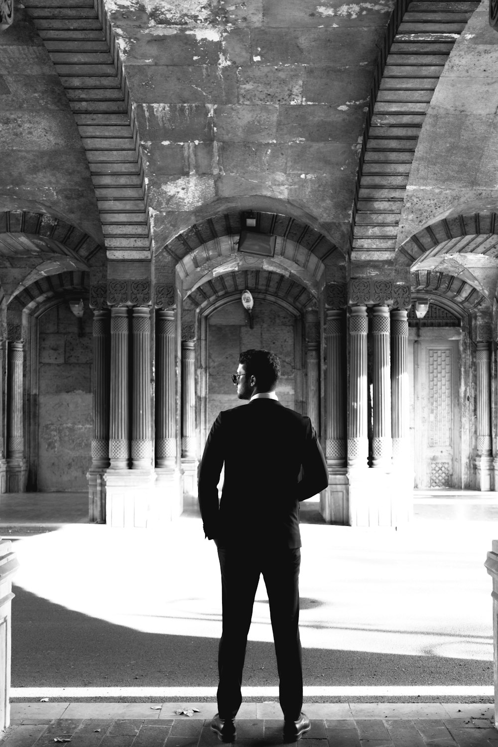 a man in a suit standing in an old building