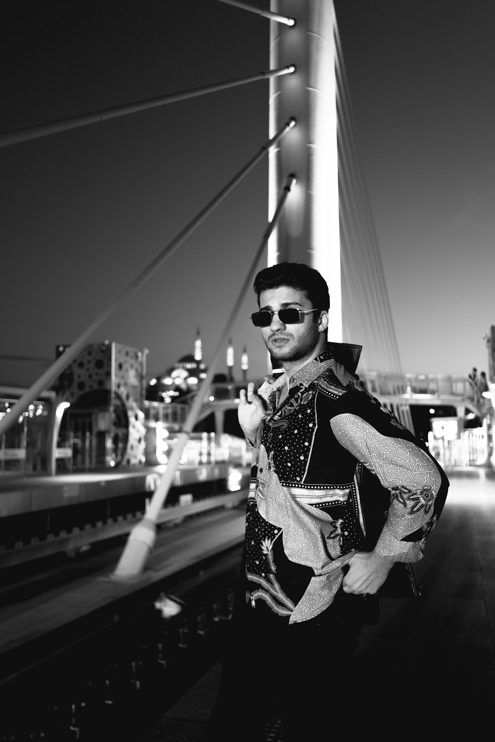 a man standing on a train track in front of a bridge