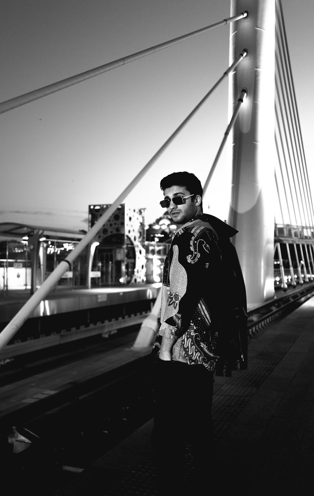 a man standing on a bridge with a cigarette in his mouth