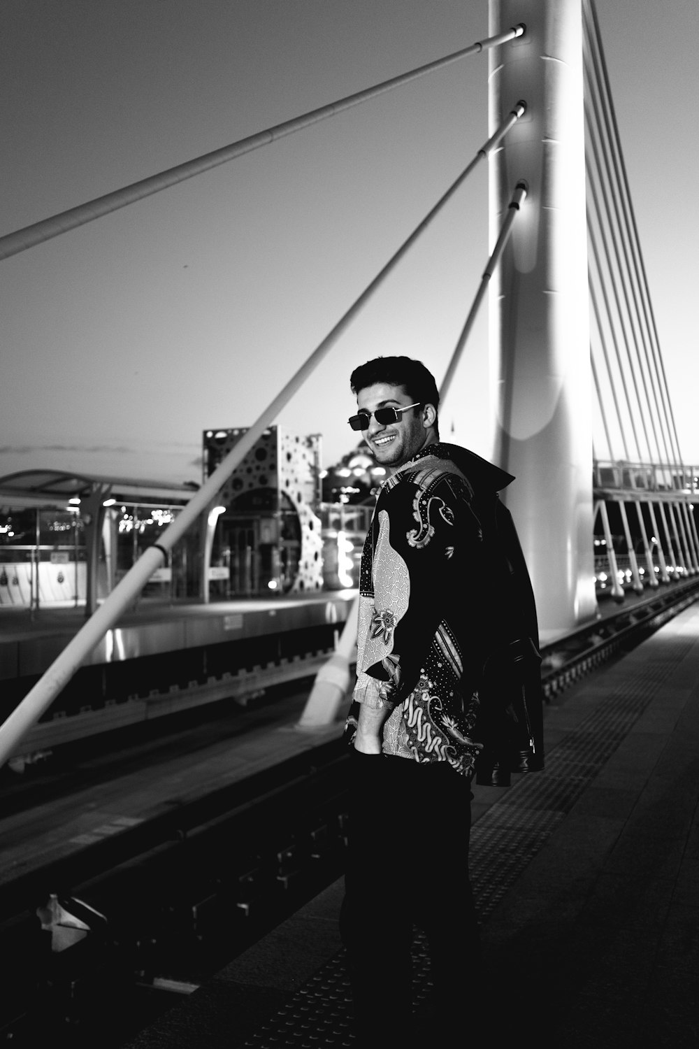 a man standing on a bridge next to a train track