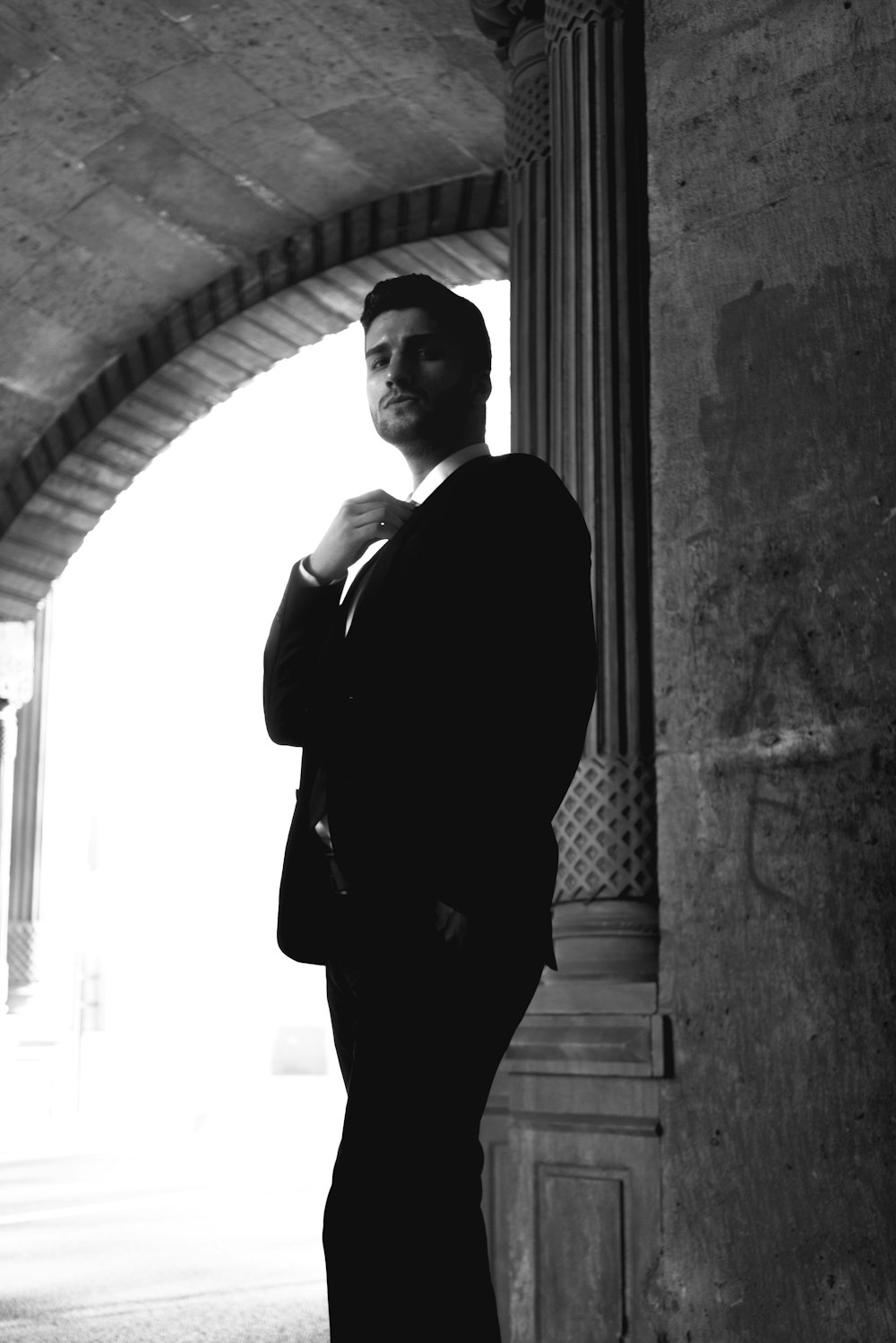 a man in a suit standing in a tunnel