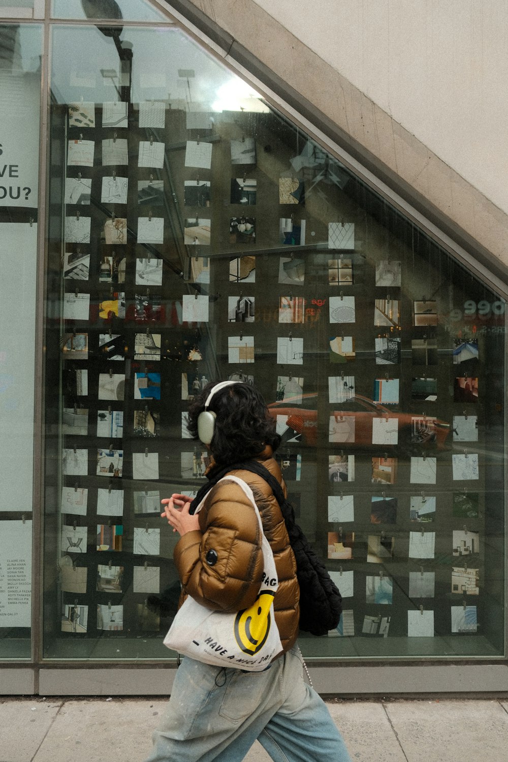 a woman walking down a sidewalk next to a building