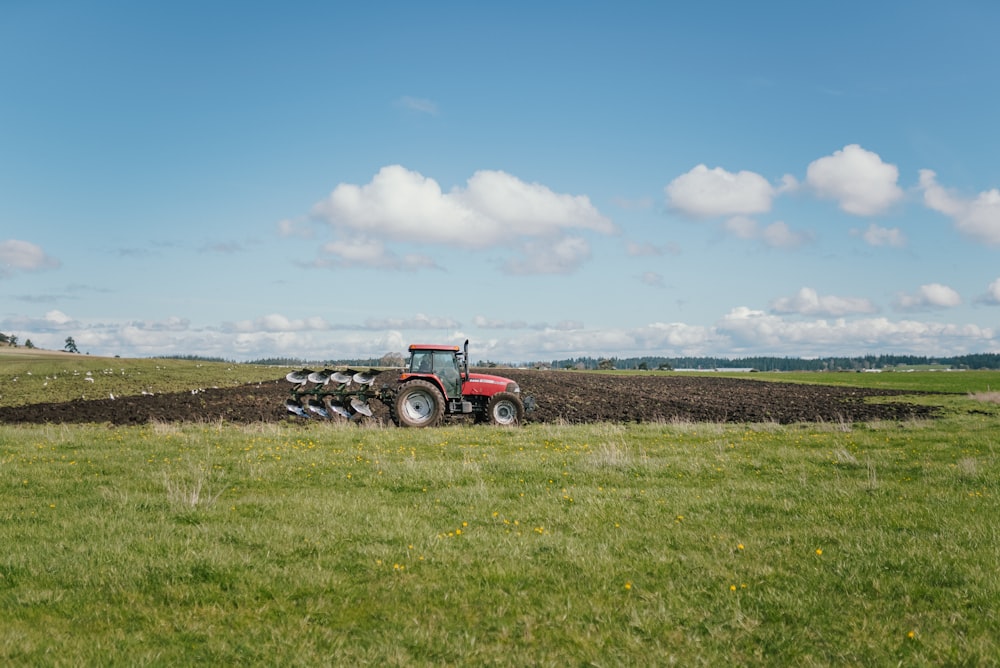 um trator arando um campo com um arado