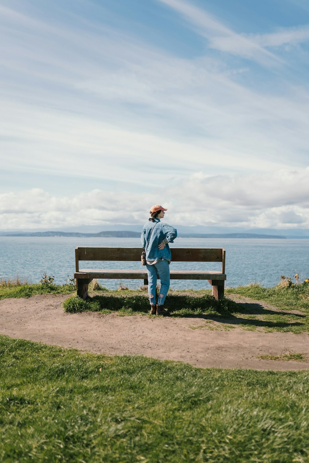 a person sitting on a bench looking at the water