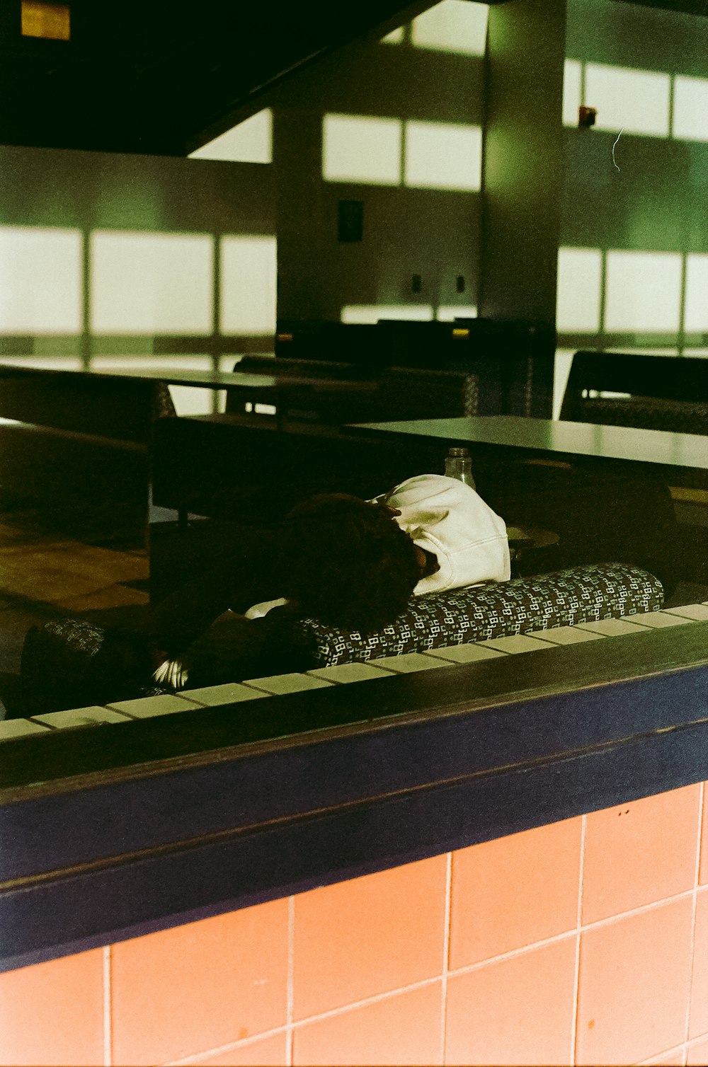 a person laying on a bench in a building