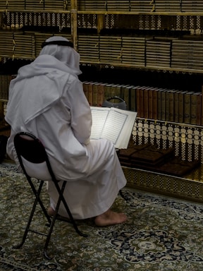a person sitting in a chair reading a book