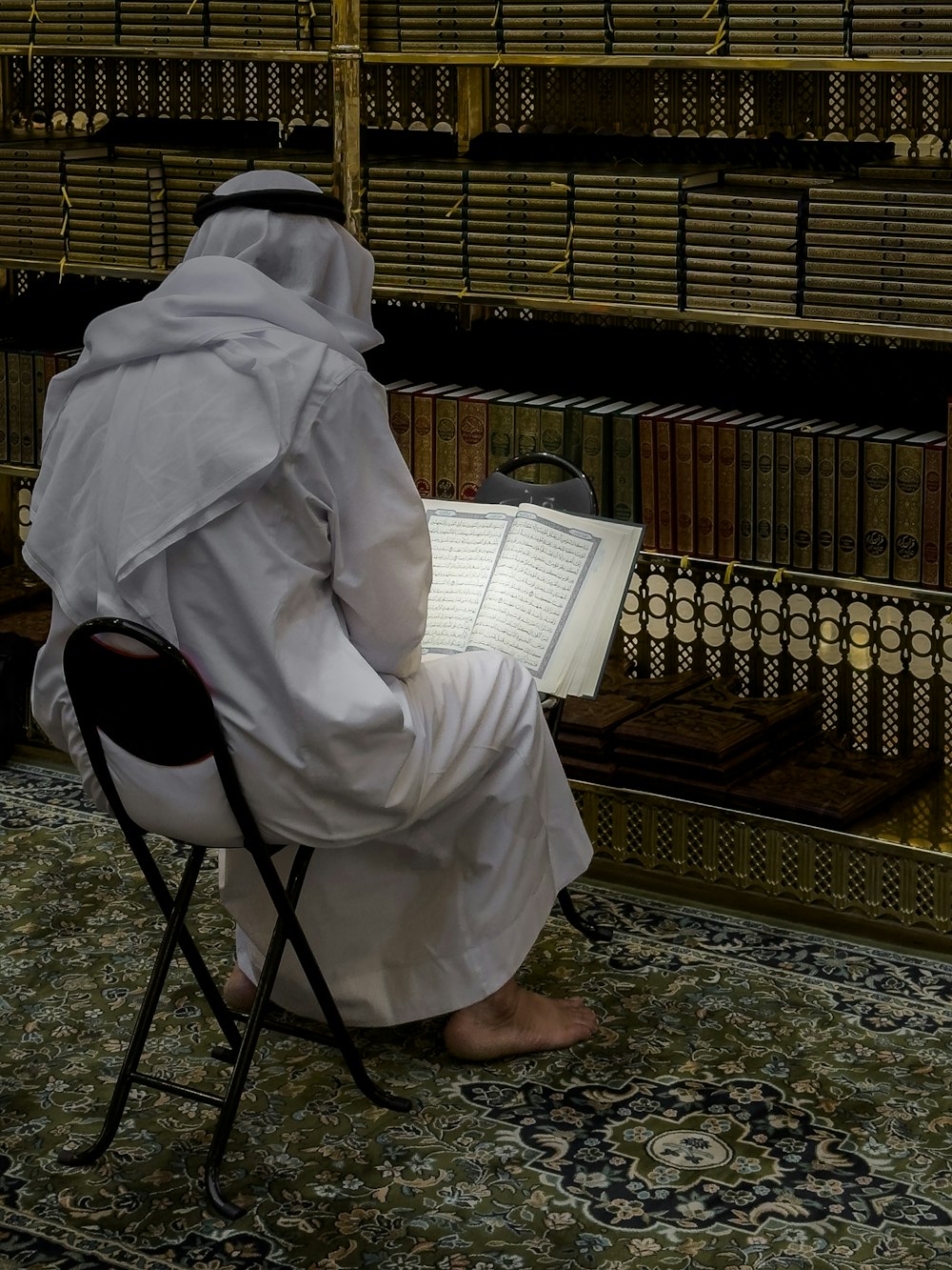 a person sitting in a chair reading a book