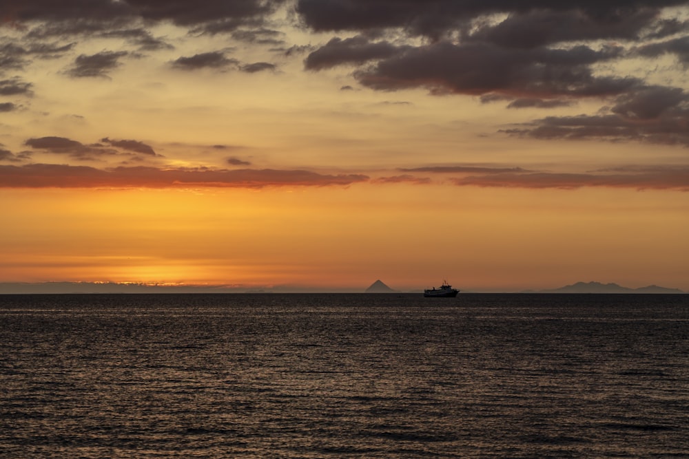 a boat is out on the water at sunset