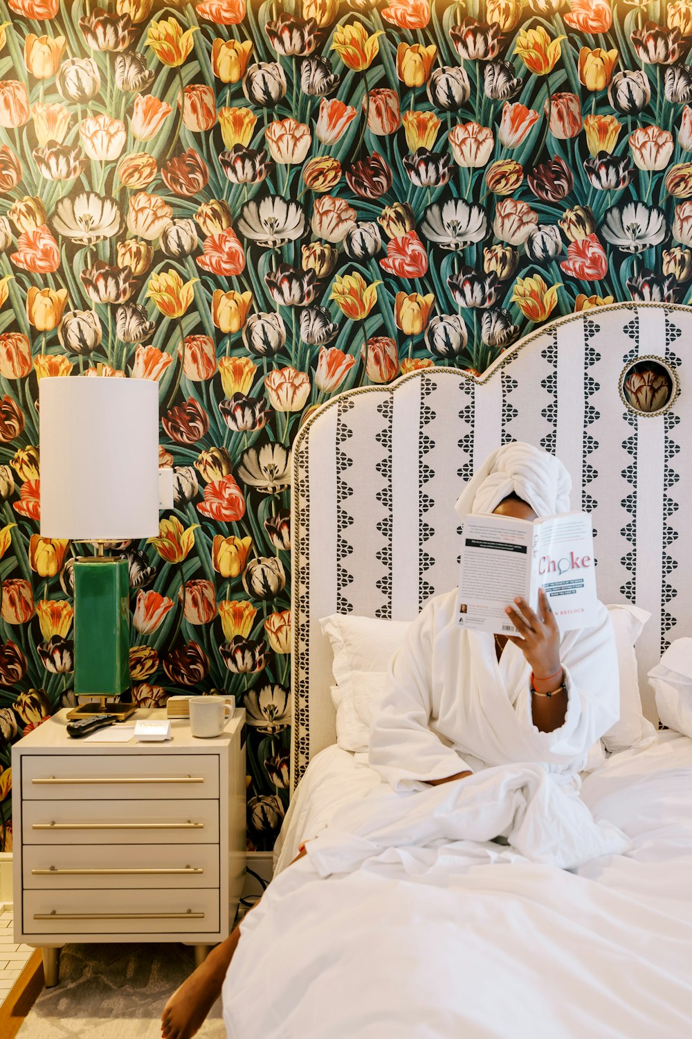 a person laying on a bed reading a book