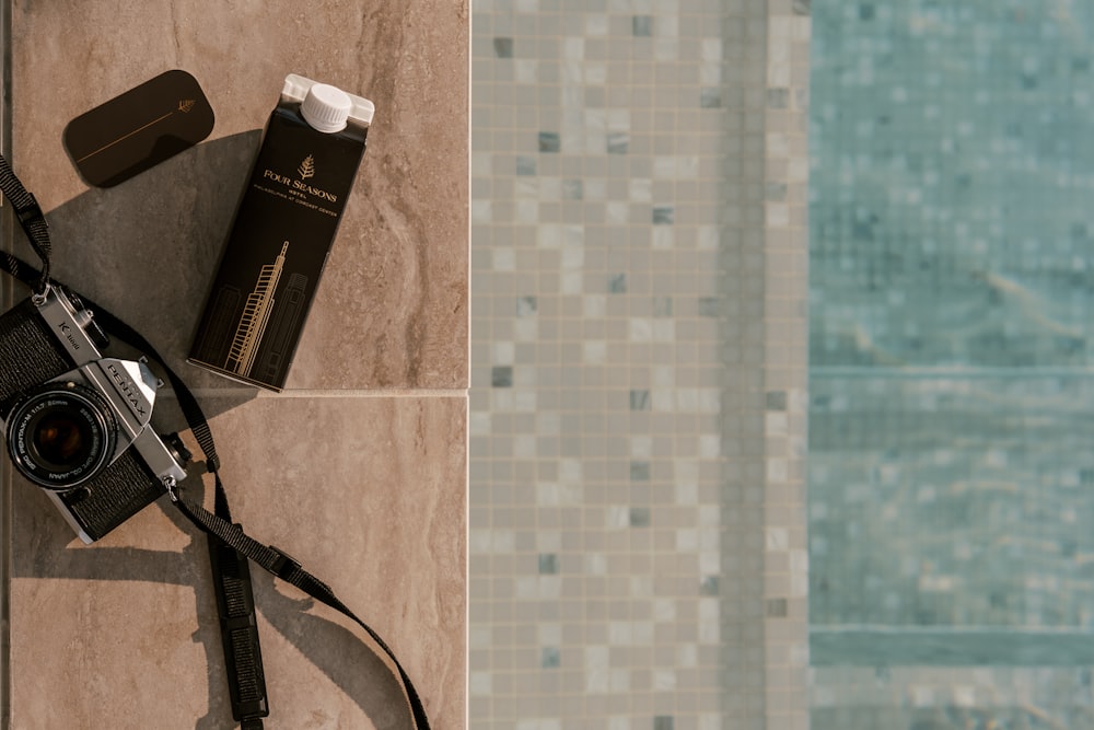 a camera and a tube of toothpaste on a tiled floor