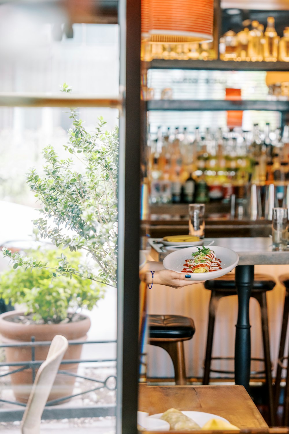 a table with a plate of food on it in front of a bar