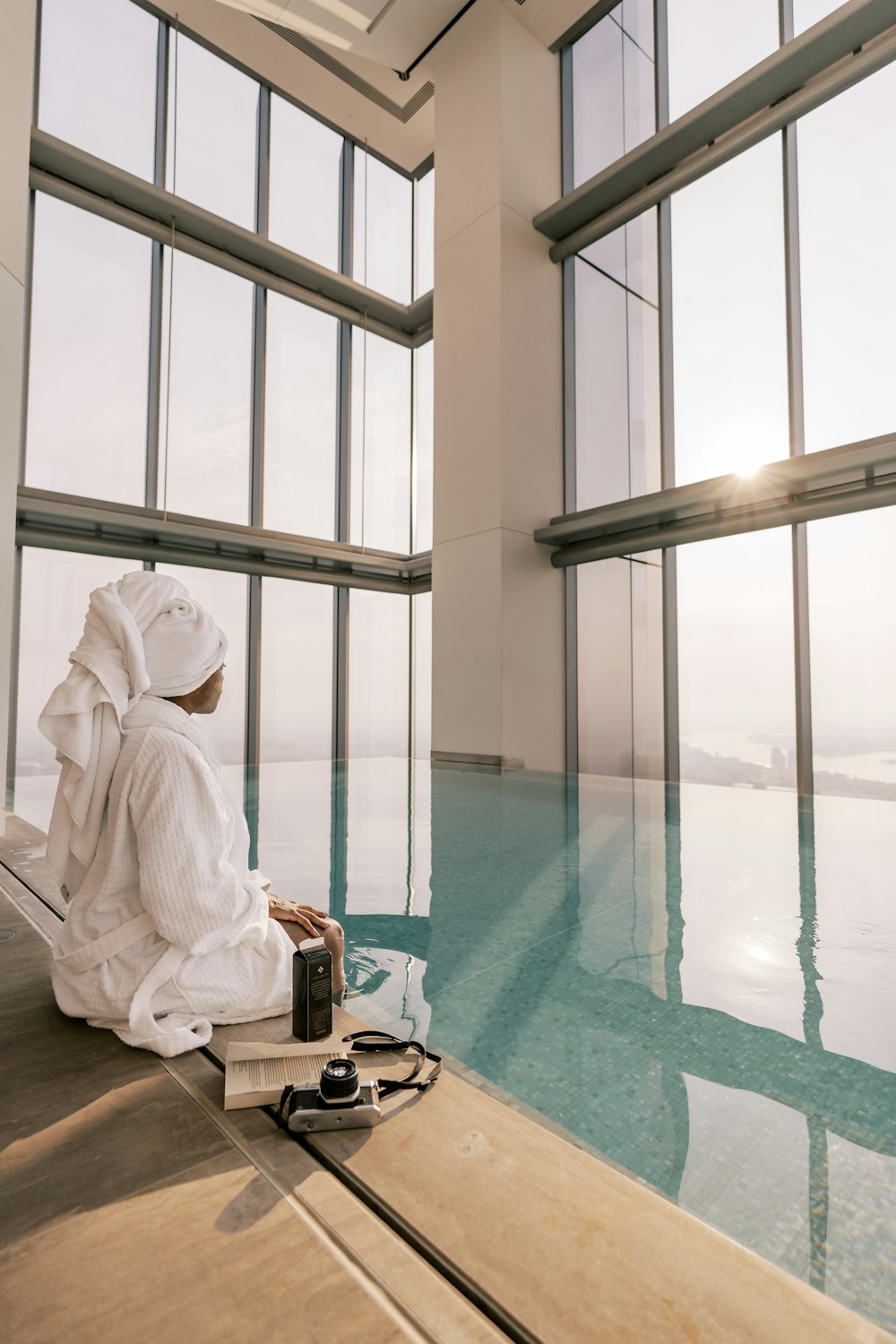 a person sitting on the edge of a swimming pool