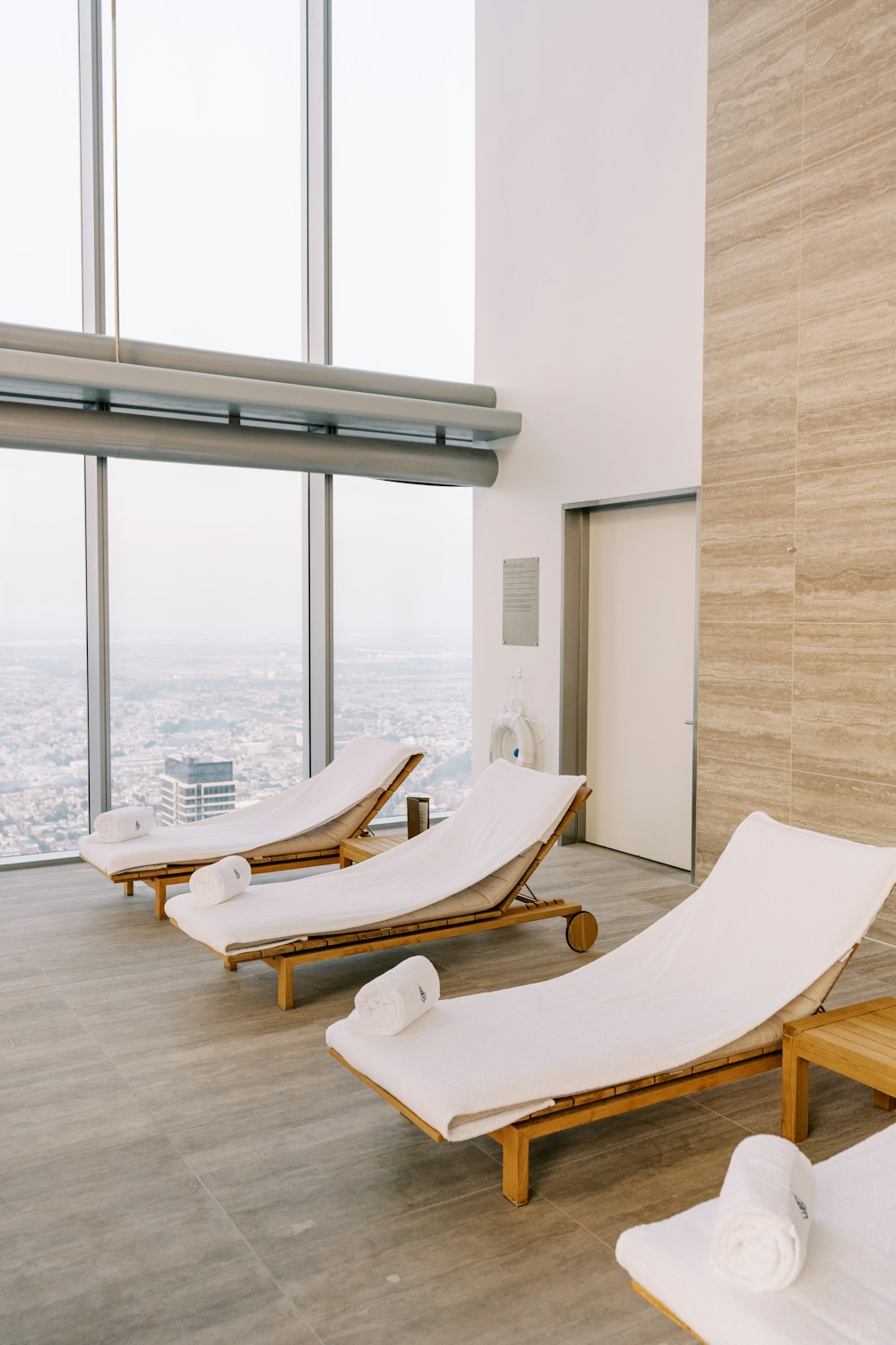 a row of chaise lounges in front of a large window