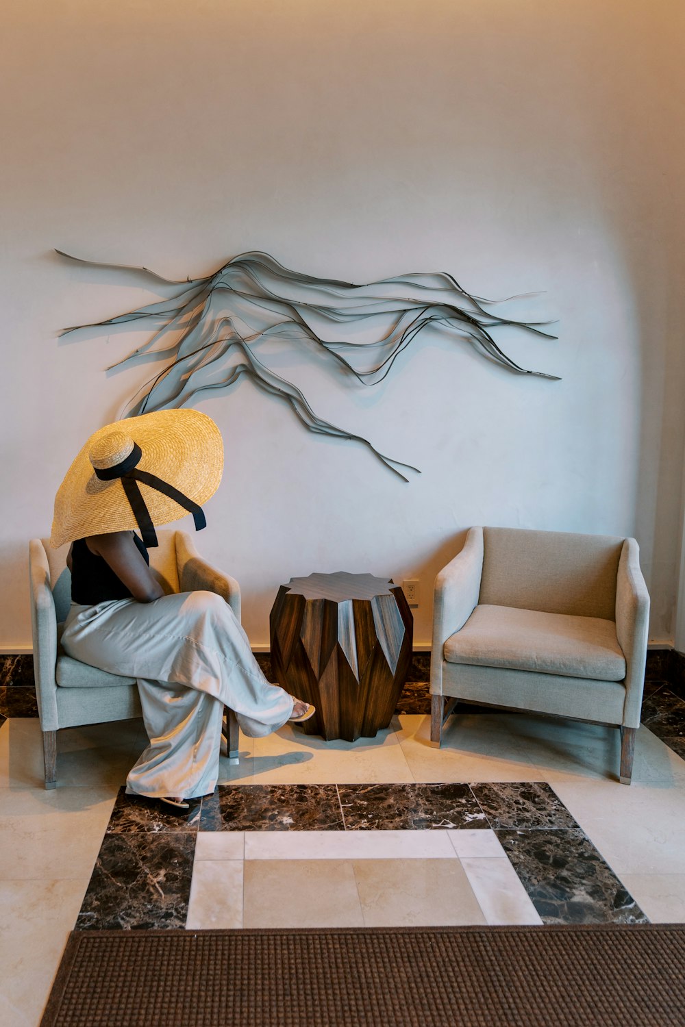 a woman sitting in a chair with a hat on her head