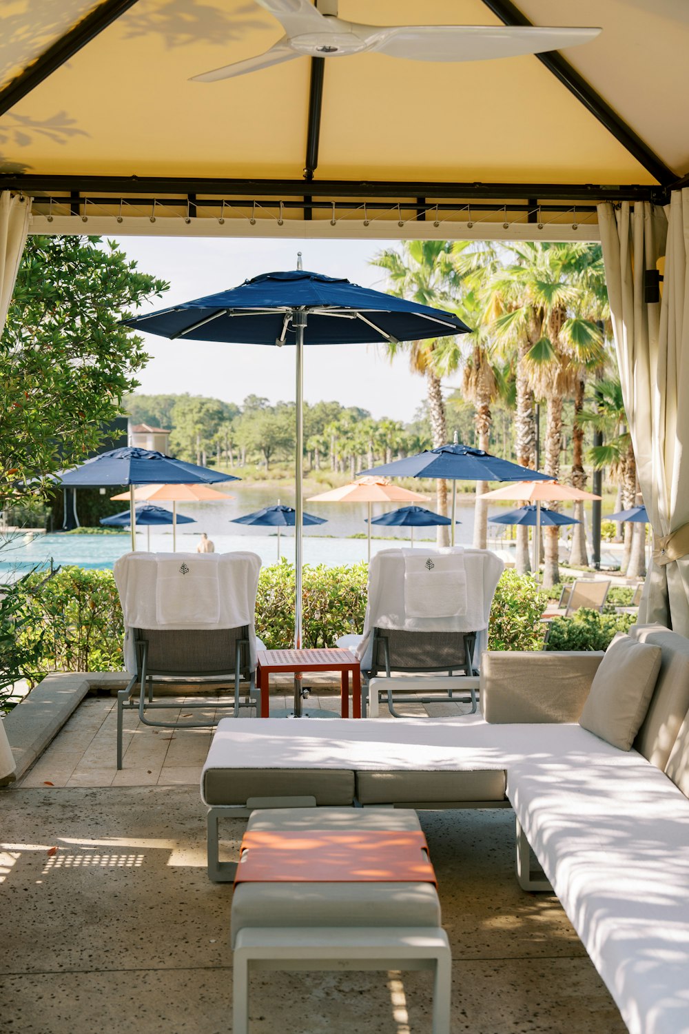 a patio with a table, chairs, and umbrellas