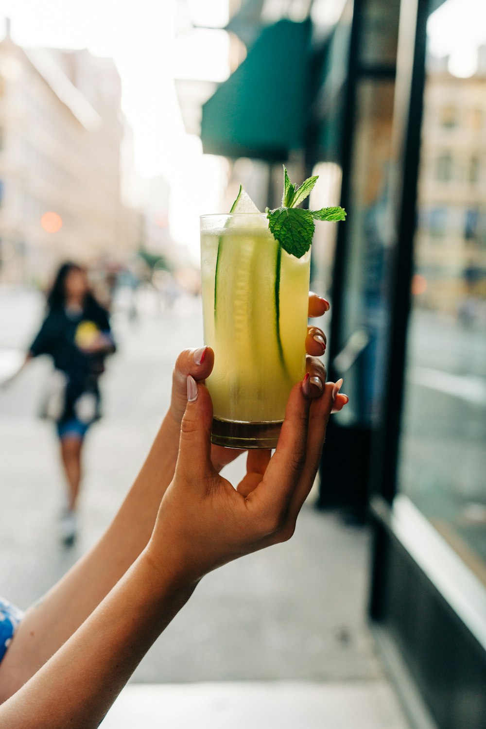 a person holding a glass with a drink in it