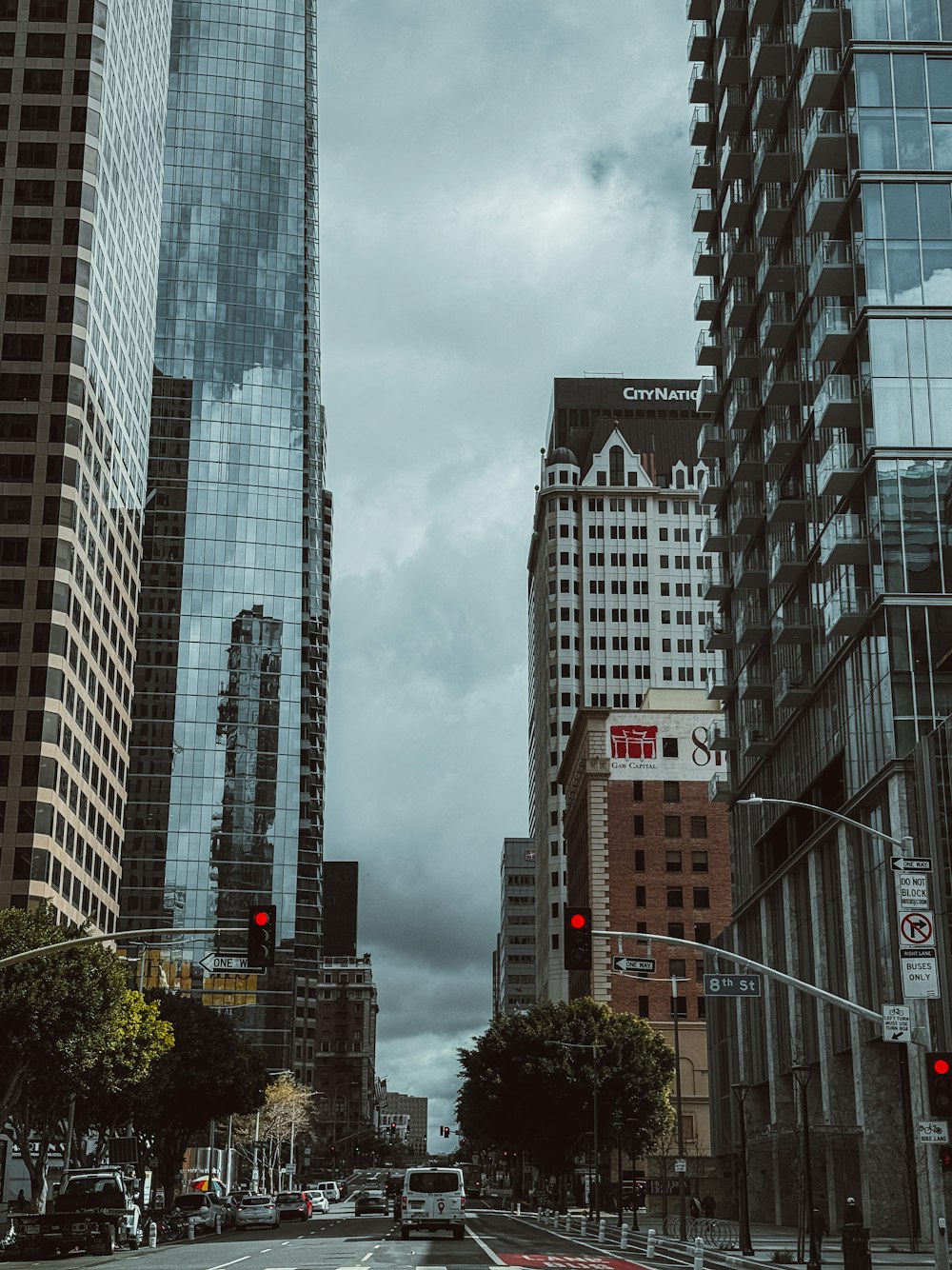 a city street filled with tall buildings under a cloudy sky