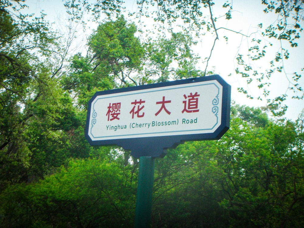 Un letrero que está frente a unos árboles