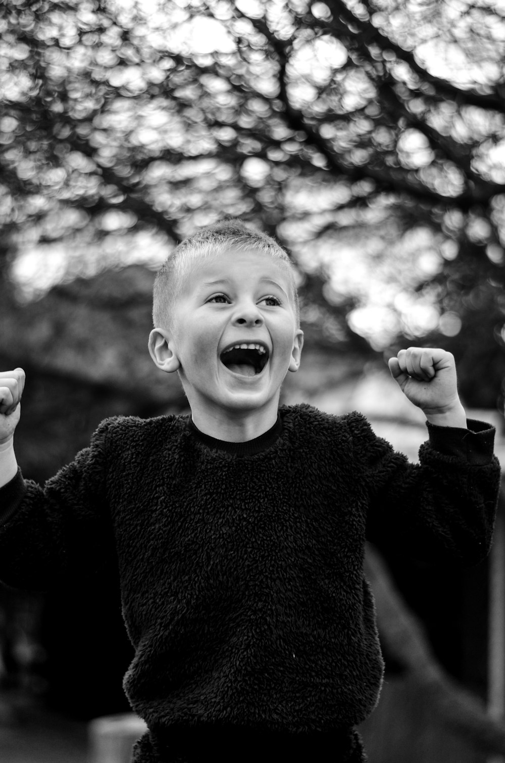 a young boy with his arms in the air