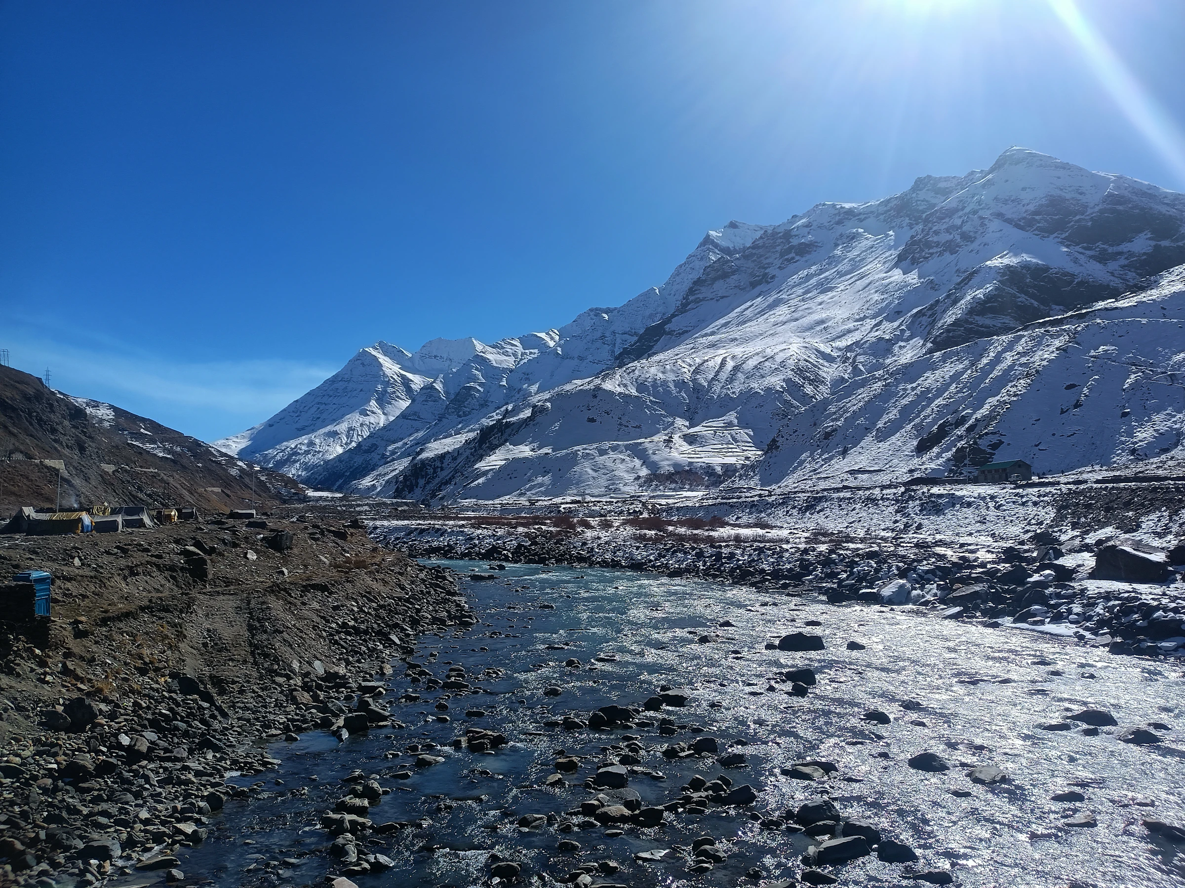 Sun lighting snowy mountains above Manali