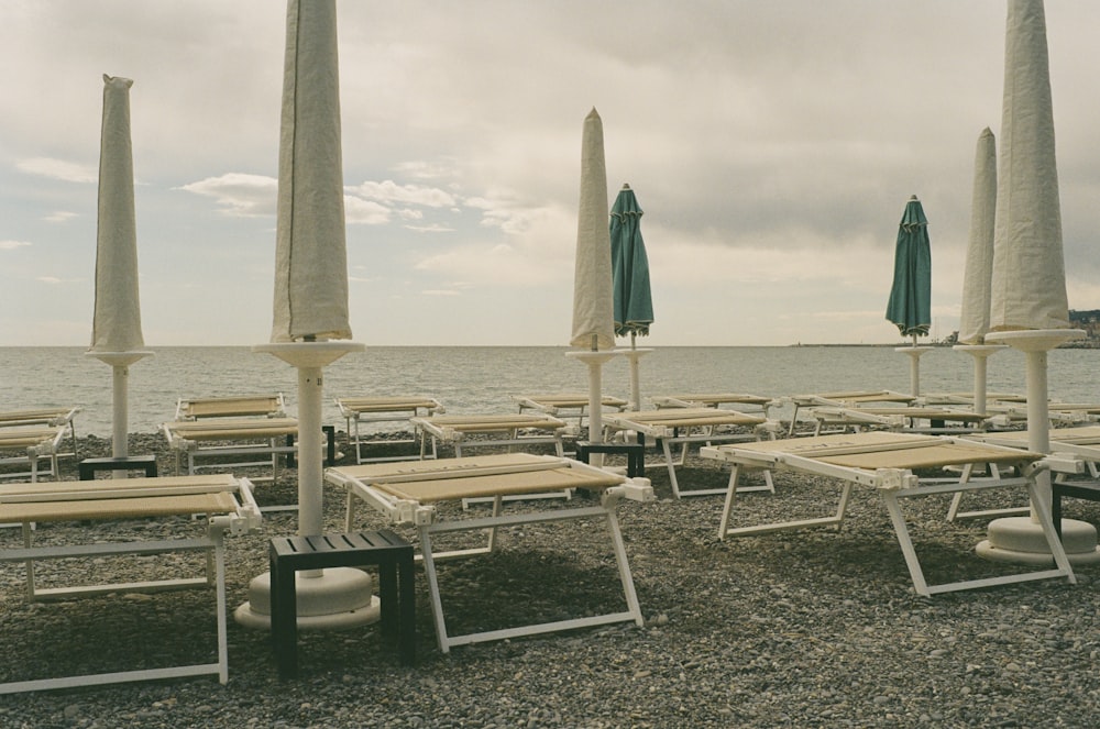 ein Haufen Stühle und Sonnenschirme am Strand