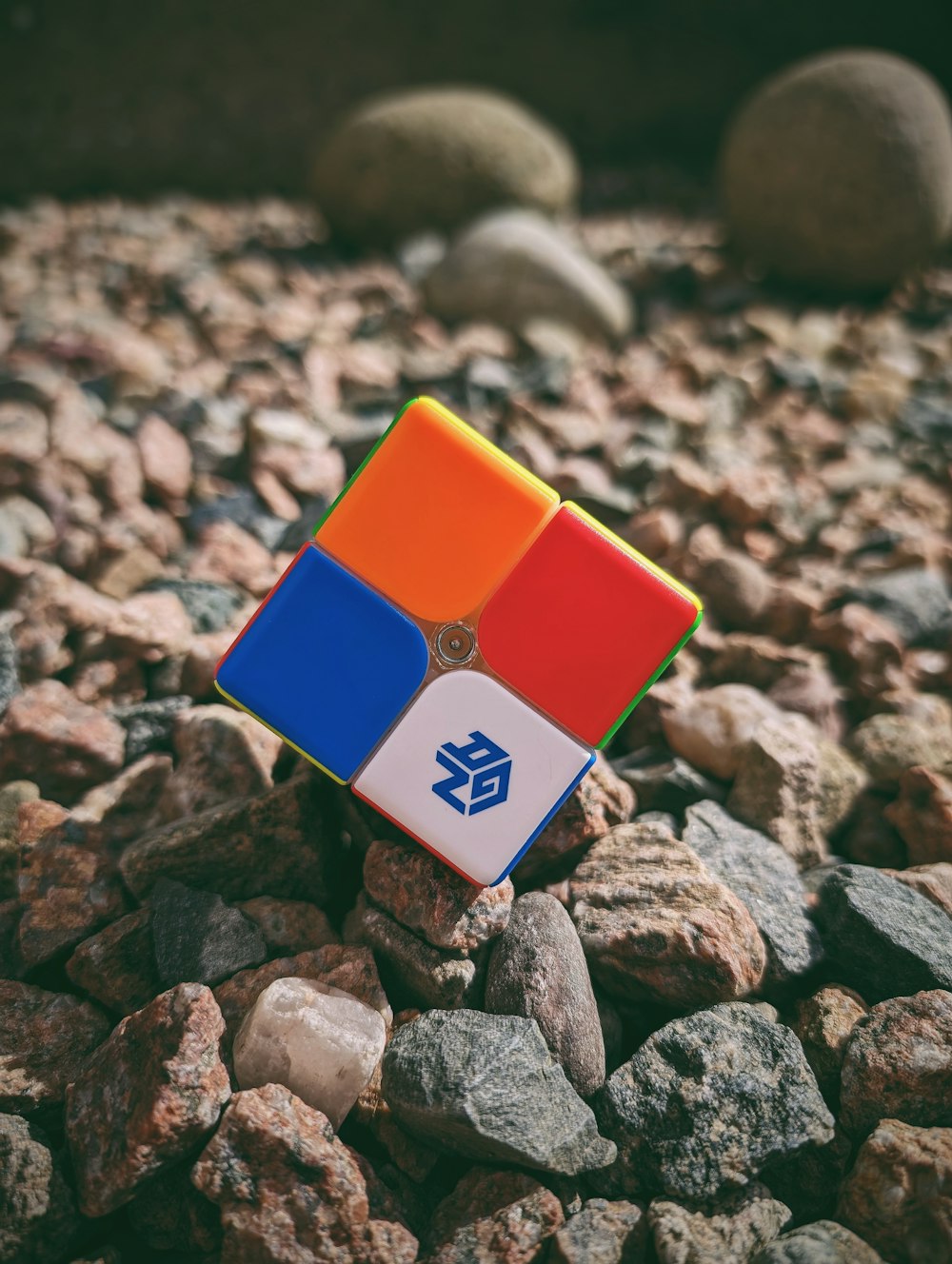 a rubik cube sitting on top of a pile of rocks